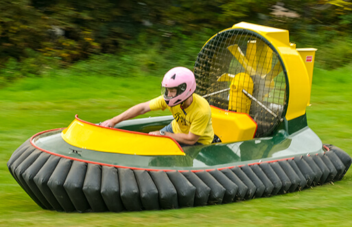 Someone driving a hovercraft across grass