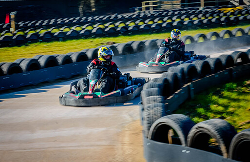 A couple of go karts driving around a track
