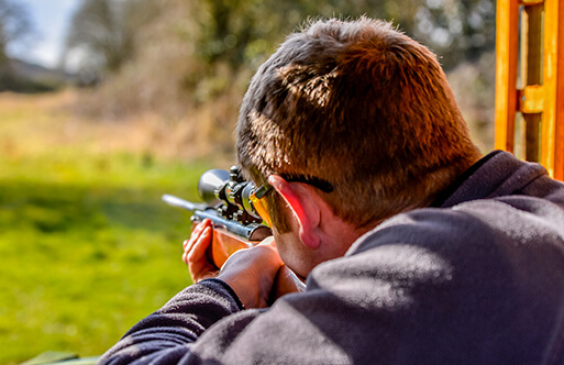 A man aiming down range with a rifle