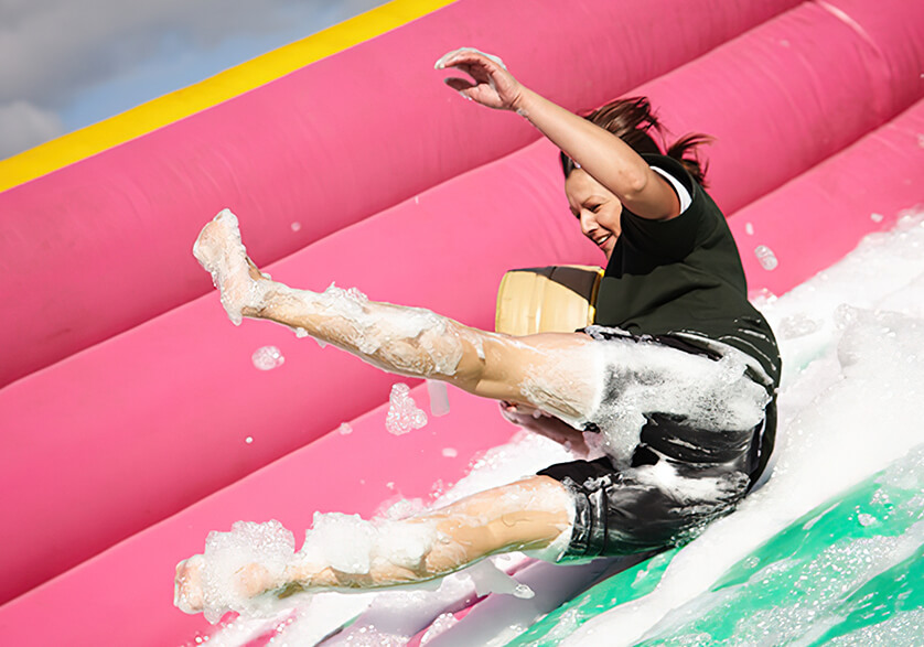 A woman sliding down a foamy slide