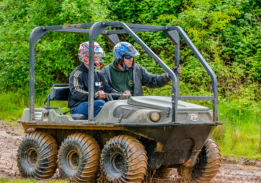 An instructor teaching someone how to drive a 7 wheel off road car