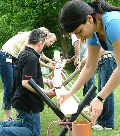 A team trying to filter water down to a bucket