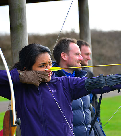 A lady pulling back on a bow and arrow