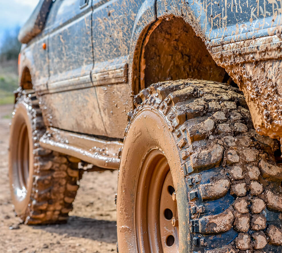 A close up of a muddy 4x4 car