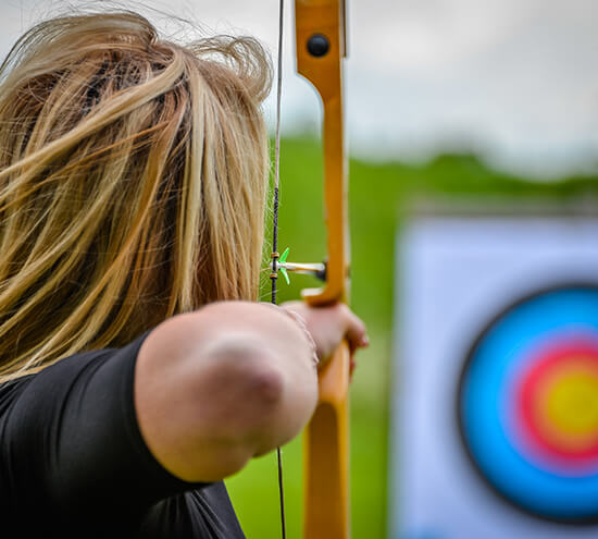 A woman pulling back on a bow and arrow