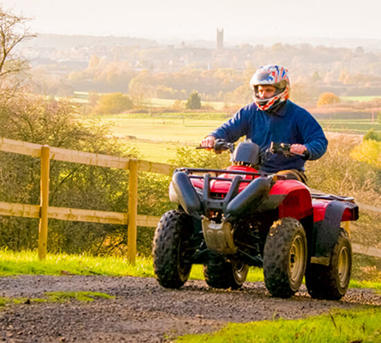 A man riding a quad bike up a hill