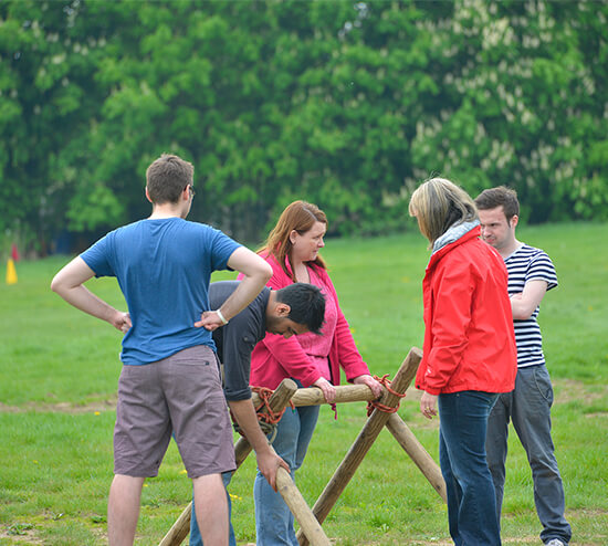 A group trying to figure out how to build a wooden structure