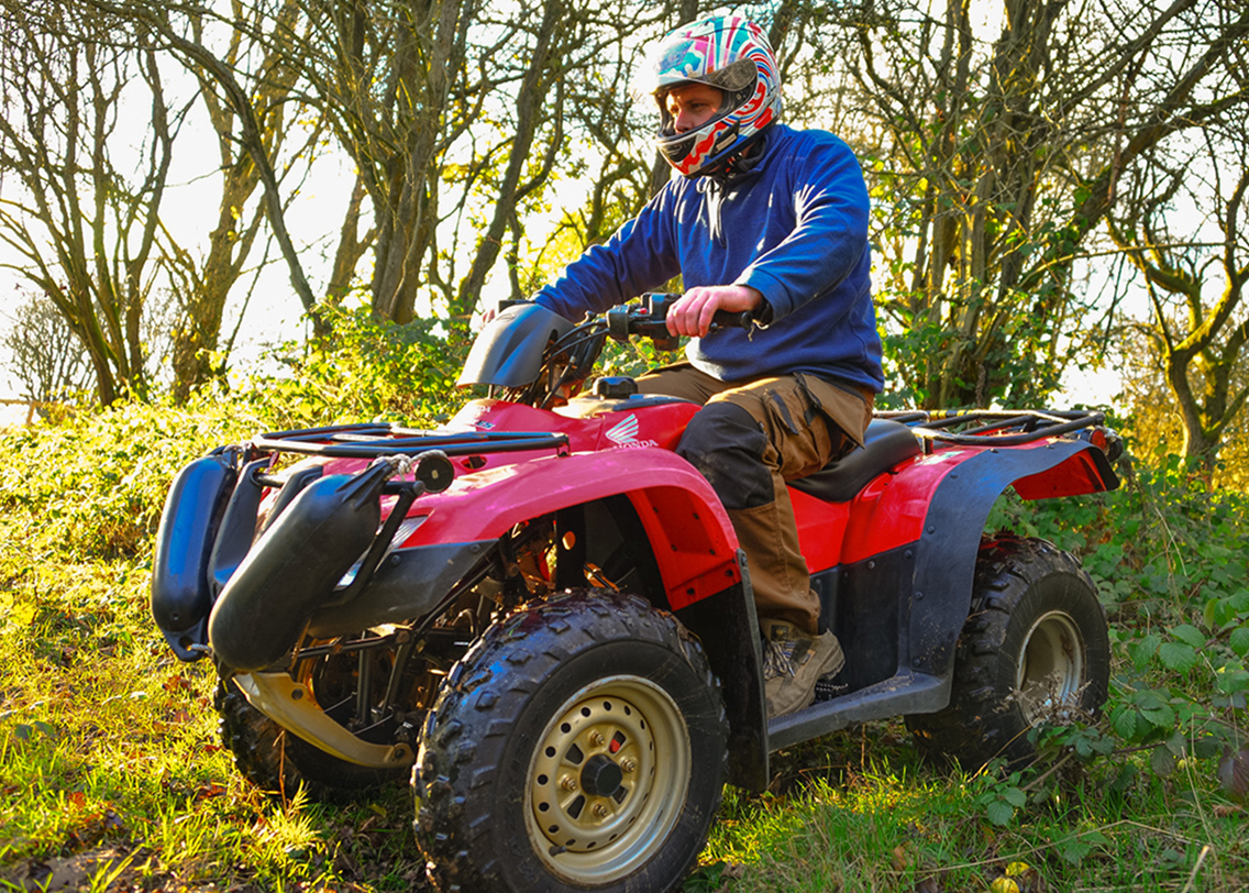A man sat on a read quad bike