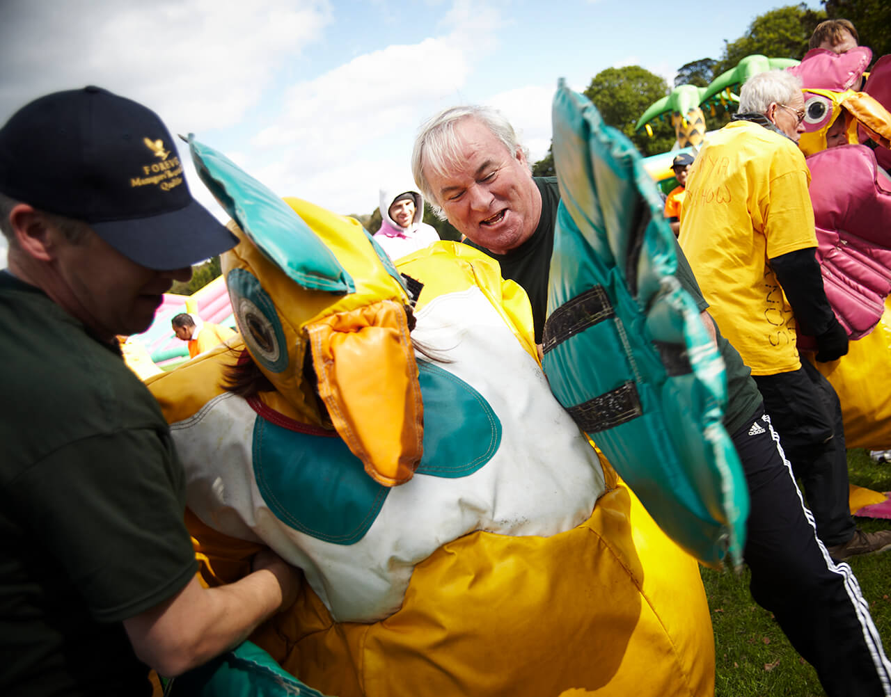 A group helping someone dressed as a chicken