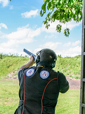 Someone aiming a shotgun down range