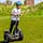 A boy driving a segway leaning forwards