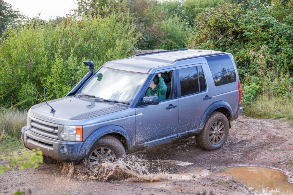 4x4 off-road driving experience through a muddy course during a corporate activity day at Adventure Sports Warwick