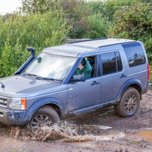 4x4 off-road driving experience through a muddy course during a corporate activity day at Adventure Sports Warwick