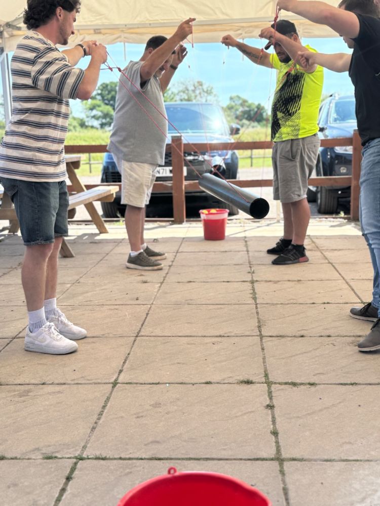 Team working together on the Level Crossing outdoor team building challenge at Adventure Sports in Warwick