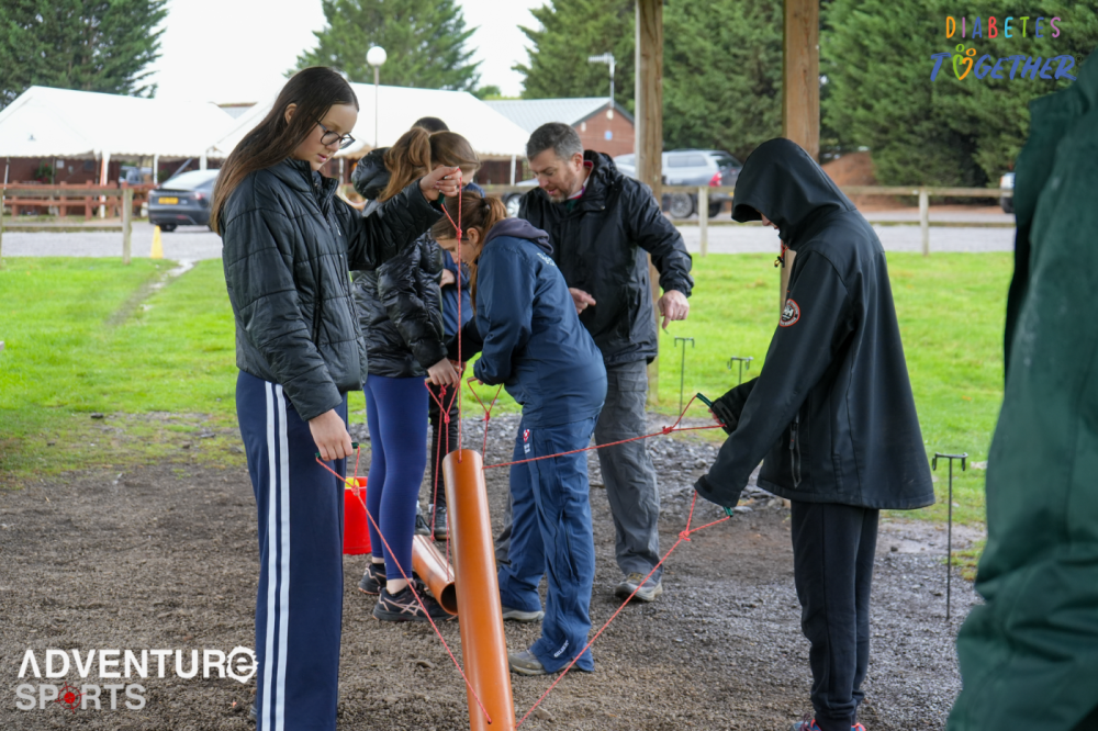 Group communicating and working together during an outdoor team building challenge at Adventure Sports Warwick