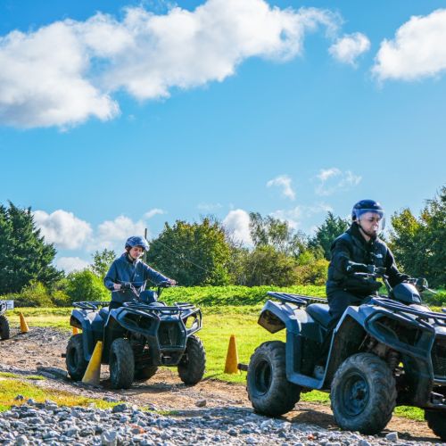 Group riding quad bikes around the off-road course during a corporate activity day at Adventure Sports Warwick
