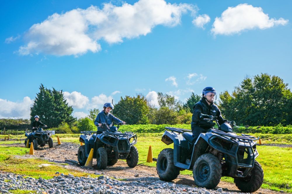 Group riding quad bikes around the off-road course during a corporate activity day at Adventure Sports Warwick